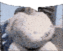 a white teddy bear with a crown on its head is sitting on a bed .