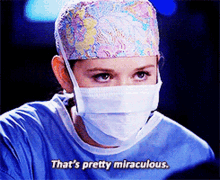a woman wearing a surgical mask and a cap says that 's pretty miraculous