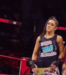 a woman in a wrestling ring is wearing a shirt that says ' wwe ' on it