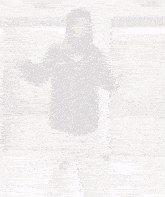 a man in a hoodie is standing in front of an elevator .