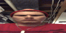 a man wearing a red beanie and a red shirt with a necklace around his neck