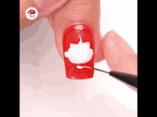 a close up of a person 's nails being painted red and white with a pen .