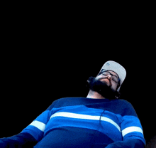 a man with a beard wearing headphones and a hat .