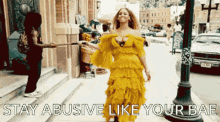 a woman in a yellow dress is walking down the street