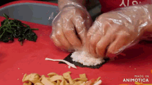 a person wearing plastic gloves is preparing food on a cutting board made by animotica