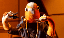 a stuffed bird wearing a sweater and scarf is making a peace sign