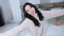 a woman is laying on a bed with her arms outstretched