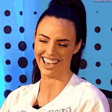 a close up of a woman laughing with her eyes closed .