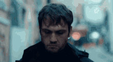 a man in a black jacket is walking down a dark alleyway