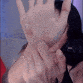 a woman is covering her face with her hand while sitting on a couch .