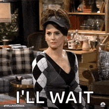 a woman wearing a hat and sweater is sitting in a living room .