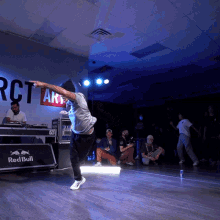 a man dancing in front of a red bull sign