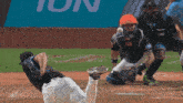 a baseball player throws a ball in front of a sign that says fun