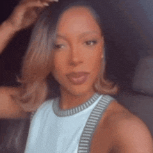 a woman is taking a selfie in a car with her hand in her hair