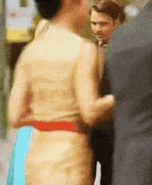a blurry picture of a woman in a yellow dress and a man in a suit