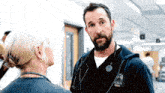 a man with a beard is wearing a name tag that says ' burch ' on it