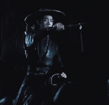 a man wearing a hat and holding a sword