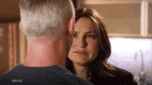 a man and a woman are looking at each other in a kitchen and the woman is crying .