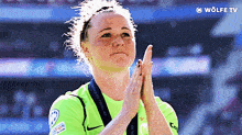 a woman wearing a green nike shirt is clapping her hands