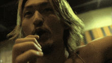 a man with long hair and a beard is eating