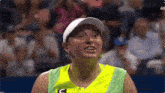 a woman wearing a yellow and green shirt with a c on it