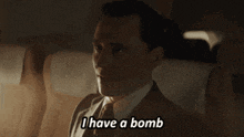 a man in a suit and tie is sitting in a car and says i have a bomb