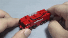 a person is playing with a toy fire truck that says morita on the side