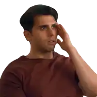 a man wearing a maroon shirt is touching his forehead
