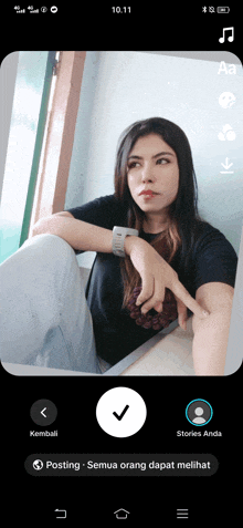 a phone screen shows a woman sitting on the floor