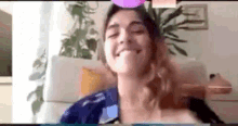 a woman is making a funny face while sitting in front of a computer screen .