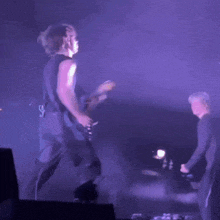 a blurry photo of a person playing a guitar on stage