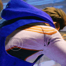 a person wearing a blue cape has a circle around their back