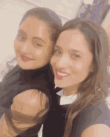 two women are taking a selfie together and smiling .