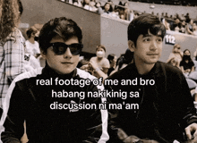 two young men wearing sunglasses and a puma jacket are sitting in a stadium