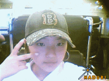 a young girl wearing a hat with the letter b on it