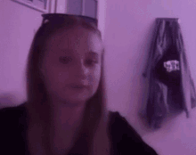 a young girl wearing sunglasses is sitting in a purple room .