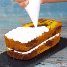 a cake is being frosted with white frosting and the words easy plus are on the bottom right