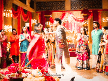 a bride and groom are dancing in front of a crowd and the words mannhearts are on the bottom left