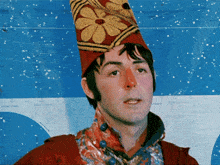 a man wearing a clown costume with a flower hat on his head