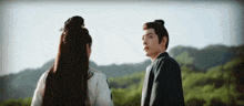 a man and a woman are standing next to each other in a field .