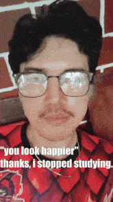 a man wearing glasses and a red shirt with the words " you look happier thanks i stopped studying "