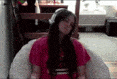 a girl wearing headphones is sitting on a bean bag chair