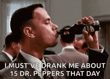 a man in a suit and tie drinking a bottle of dr pepper