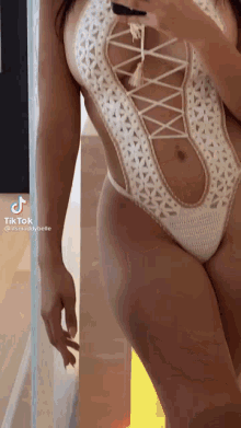 a woman is taking a selfie in a crocheted swimsuit .