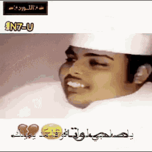 a man in a white hat is smiling with arabic writing on the bottom