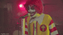 a clown sings into a mcdonald 's microphone