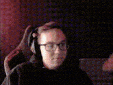 a man wearing glasses and headphones is sitting in a chair that says astralis on it