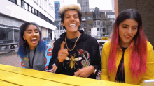 a man with a bee on his shirt is surrounded by two women