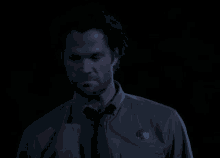 a man in a shirt and tie has a badge on his chest that says sheriff