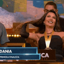 a woman in a black dress with a gold medal around her neck